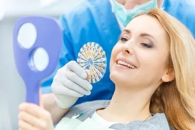 Dr. Gaither helping a patient choose a color for her new implants