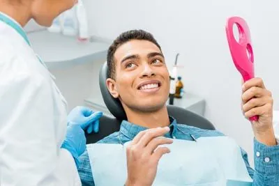 man looking in the mirror at his smile